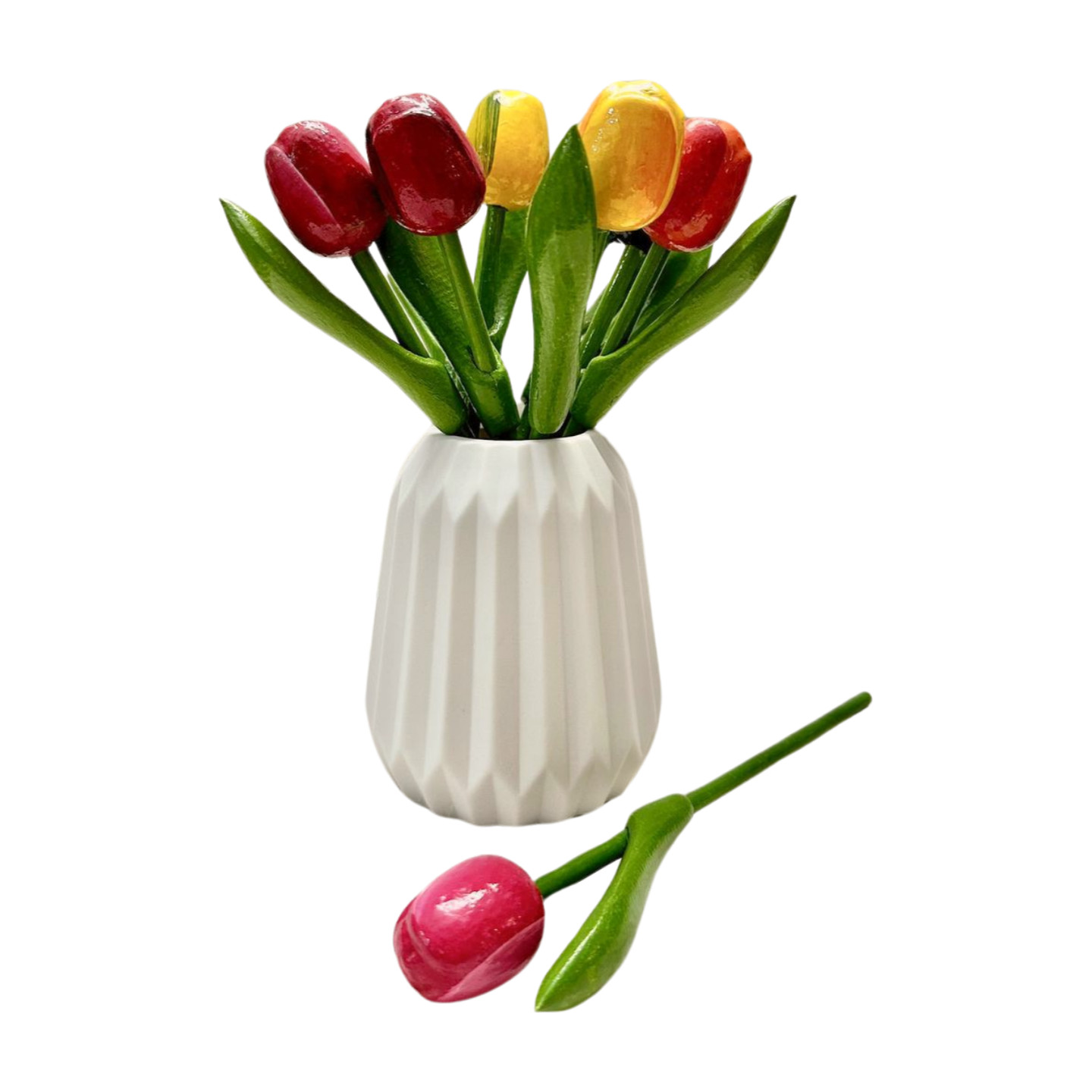 Mini wooden tulip bouquet shown in a white vase and a pink tulip laying in front of the vase for size reference.