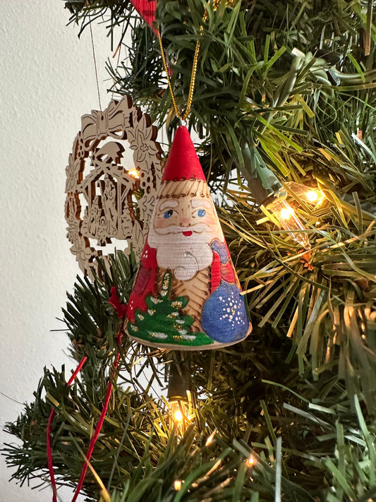 Wooden Santa Ornament hanging from a Christmas tree