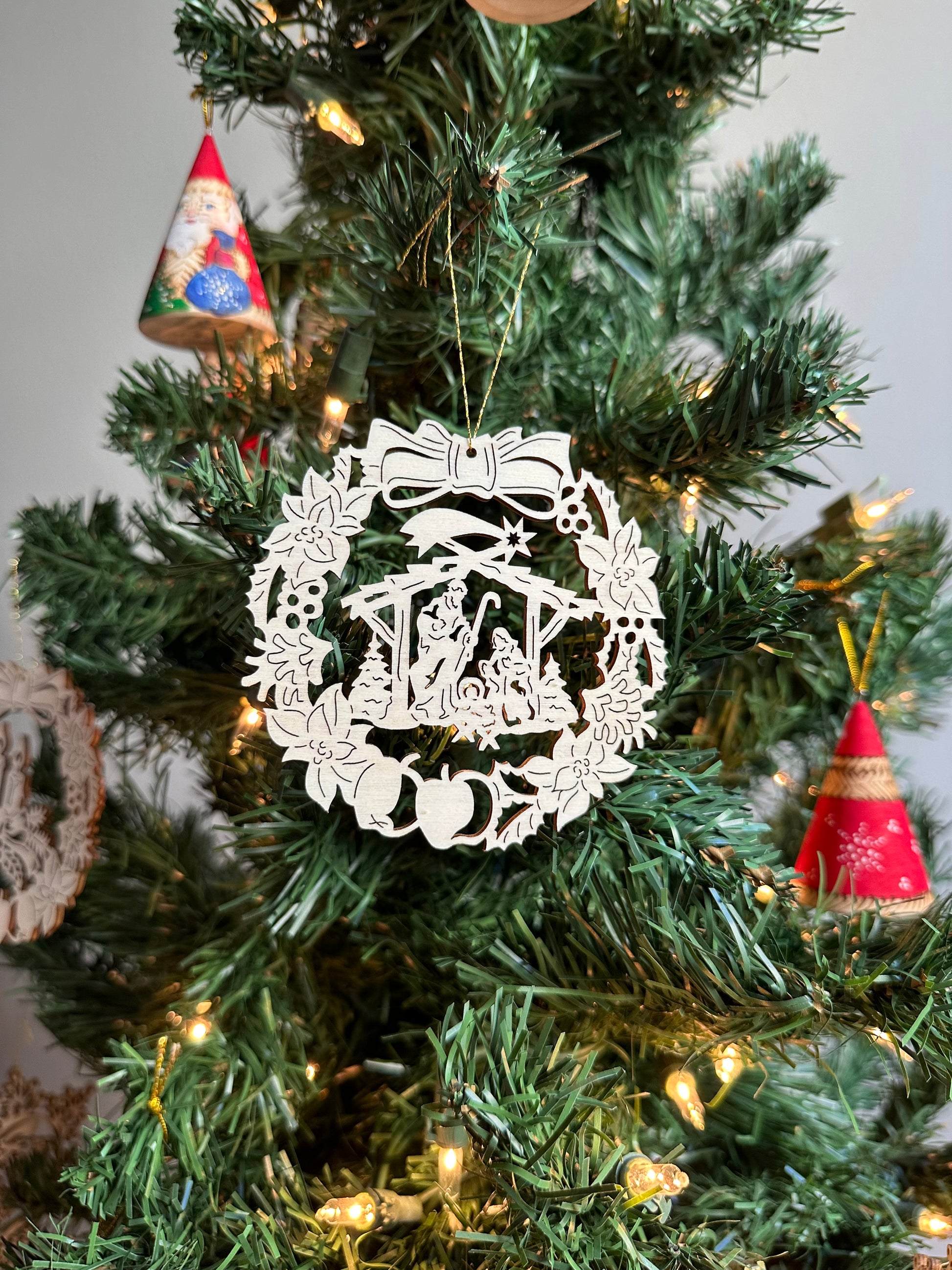 Wooden Christmas Ornament featuring a wreath and manger design.