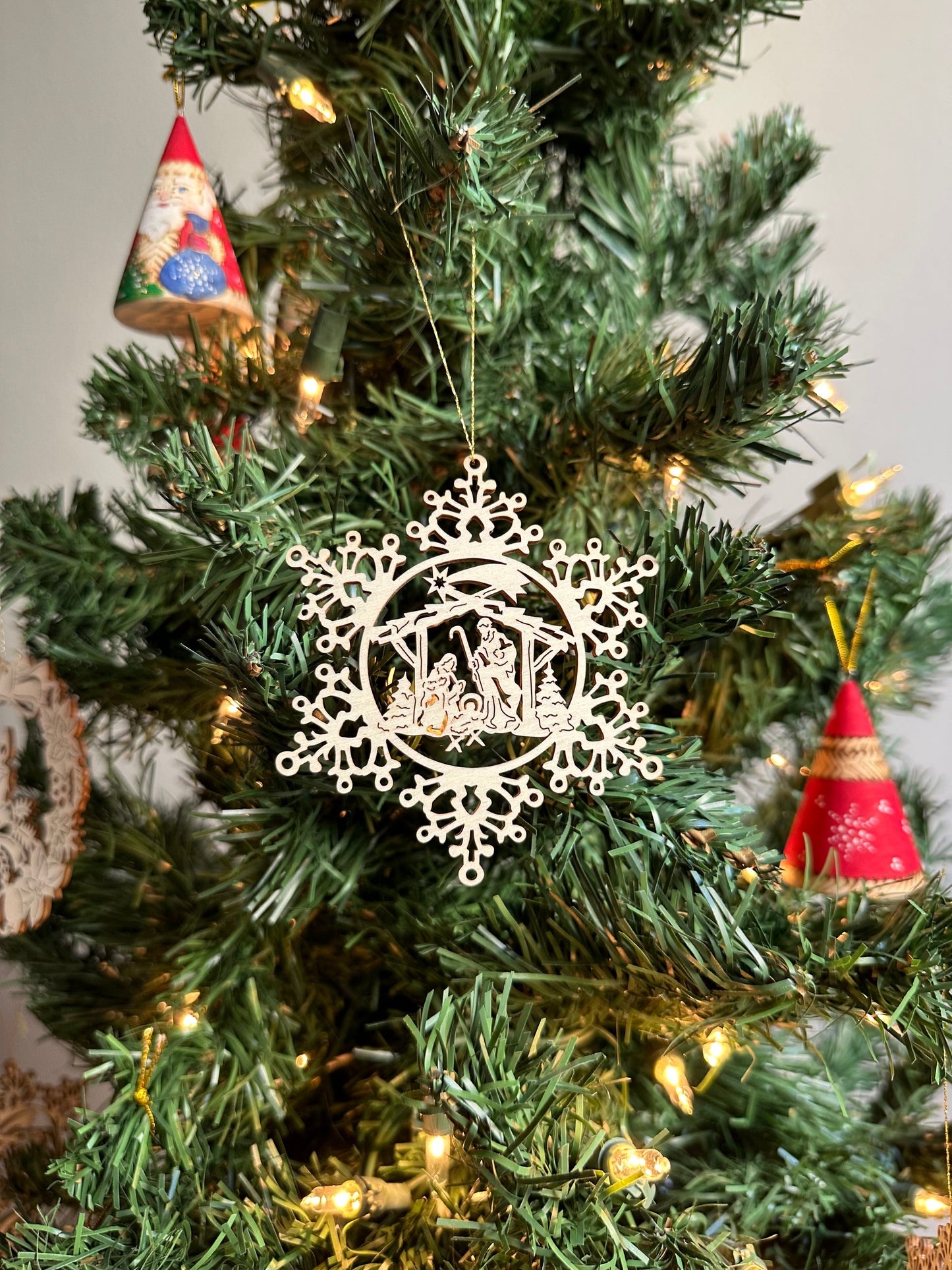 Wooden Christmas Ornament featuring a snowflake and manger design.