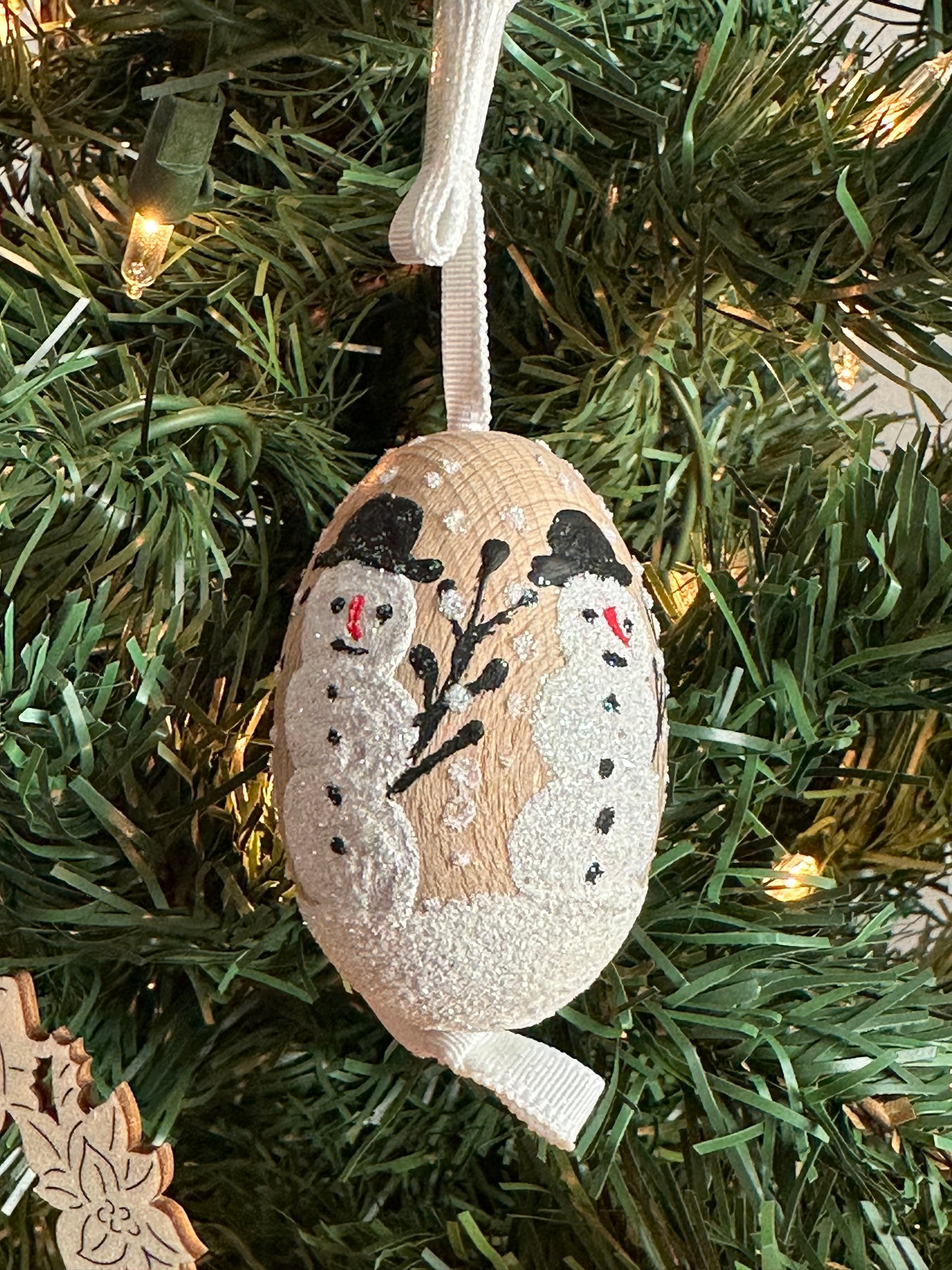 Austrian Christmas Egg Ornament featuring a glittery snowman design, hanging on a tree.