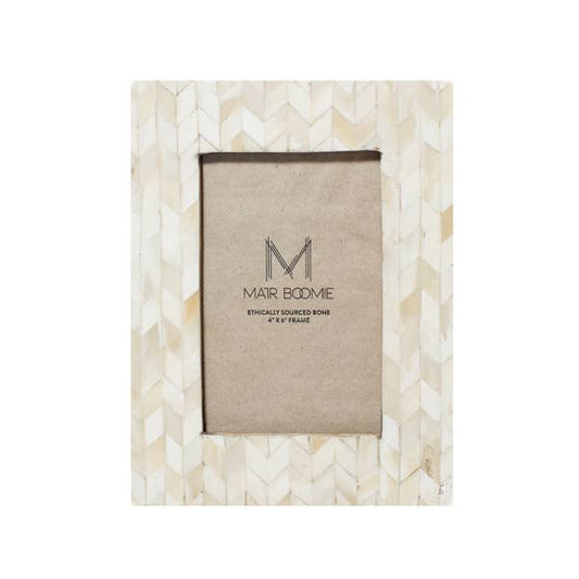 Featuring a modern and elegant chevron-patterned tile design, this picture frame will perfectly showcase 4x6 photos. The bone inlay tiles are ethically sourced and in various shades of ivory.