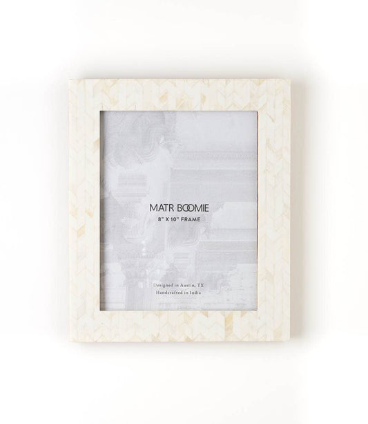 Featuring a modern and elegant chevron-patterned tile design, this picture frame will perfectly showcase 8x10 photos. The bone inlay tiles are ethically sourced and in various shades of ivory.