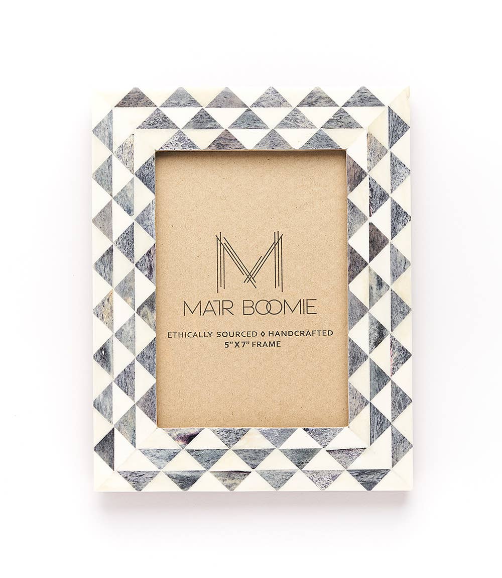 Featuring a modern geometric triangle-patterned tile design, this picture frame will perfectly showcase 5x7 photos. The bone inlay tiles are ethically sourced and in various shades of ivory and grey.